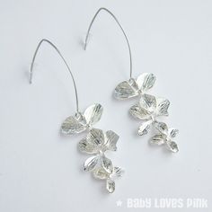 A beautiful pair of linear dangle earrings with rhodium-plated (white gold) V-shaped earwires suitable for sensitive skin.  Attractive shiny silver-plated triple tier orchid flowers.  Comes gift wrapped ready for gift giving.♥ Rhodium-plated (white gold) V-shaped linear earrings (approx. 35mm length)♥ Silver-plated triple orchid dangling charms (approx. 35mm)♥ Always gift wrapped ♥[ Matching necklace also available separately ]______________________________________________________________Follow Minimalist Sterling Silver Flower Earrings For Wedding, Silver Minimalist Dangle Flower Earrings, Dainty Silver Flower Earrings For Party, Silver Dangle Flower Earrings Minimalist Style, Delicate Silver Linear Earrings With Ear Wire, Silver Flower Shaped Hoop Earrings For Wedding, Silver Dainty Flower Earrings For Party, Elegant Flower Shaped Earrings With French Hook, Elegant Silver Linear Earrings With French Hook