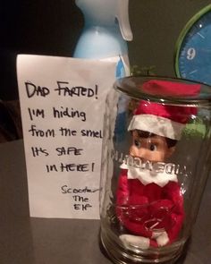 a glass jar with an elf on it next to a sign that says dad faced i'm hiding from the smell it's safe in here