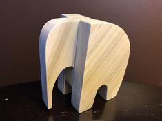 an elephant shaped wooden object sitting on top of a table