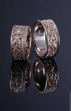 two wedding bands with intricate designs on each side, one is white gold and the other is rose gold