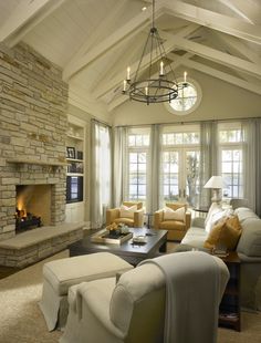 a living room filled with furniture and a fire place in the middle of a room