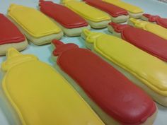 some hotdogs and buns are decorated in yellow, red, and blue icing