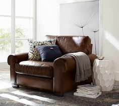 a brown leather chair with pillows on it