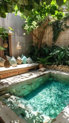 an outdoor swimming pool in the middle of a garden with stone walls and flooring