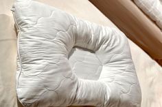 a white pillow sitting on top of a bed