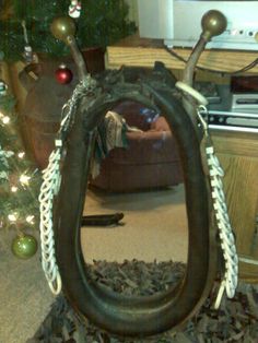 a horse shoe sitting in the middle of a pile of wood chips next to a christmas tree