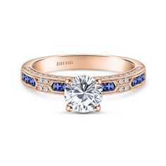 a rose gold engagement ring with blue and white stones on the side, set in 18k