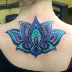 the back of a woman's neck with an intricate tattoo design on her shoulder