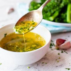 broccoli being drizzled with olive oil in a white bowl