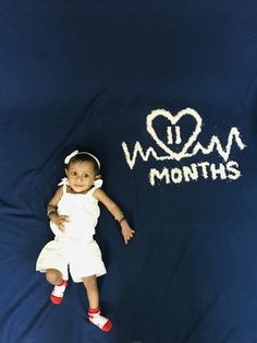 a baby laying on top of a blue blanket with the word mom written in white