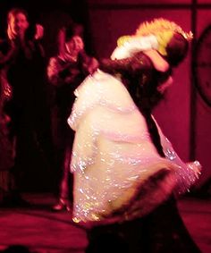 a man and woman dancing in front of a crowd