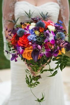 a bride holding a colorful bouquet of flowers