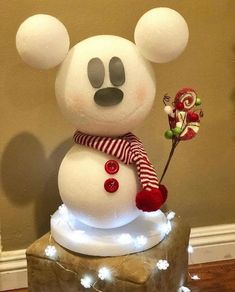 a mickey mouse snowman with candy canes on it's head and nose