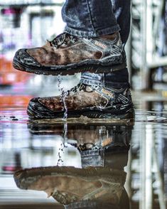 a person standing on top of a puddle with their feet in the water