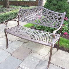 a metal bench sitting on top of a stone walkway