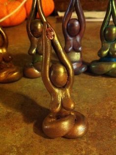 three metal figurines sitting on top of a table next to pumpkins and other decorations