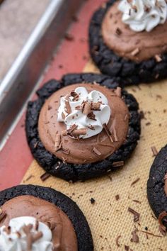 chocolate cookies topped with whipped cream and chocolate shavings