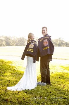 a man and woman standing next to each other in the grass