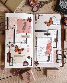 an open planner book sitting on top of a wooden table next to flowers and other items