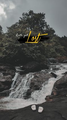 there is a pair of shoes sitting on the rocks next to a waterfall that reads lost