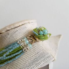 "This is a vintage 1970's statement necklace. The primary strands of the necklace are a light green seed bead. The beads are very delicate but still in good condition. The other strands of the necklace are light blue tone beads. The clasp is a silver tone metal with the same green and blue beading covering the top of the clasp. Some of the beads are missing from the top of the clasp, but it is something that is not very noticeable given the placement. The necklace is in good condition. Measureme Vintage Hand-strung Green Beaded Necklaces, Hand-strung Green Vintage Beaded Necklaces, Green Multi-strand Hand-strung Necklaces, Green Multi-strand Hand-strung Beaded Necklaces, Green Vintage Hand-strung Beaded Necklaces, Green Multi-strand Beads For Jewelry Making, Handmade Green Multi-strand Beaded Necklaces, Green Multi-strand Beaded Necklaces With Large Beads, Handmade Green Multi-strand Beaded Necklace