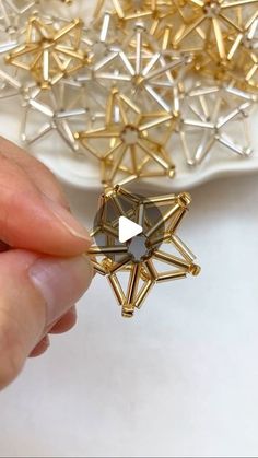 a person is holding a star brooch in their hand