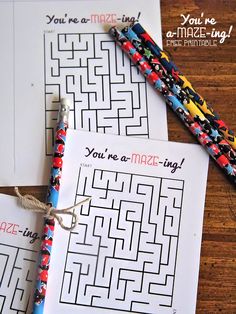 two printable mazes on top of each other next to a pen and paper