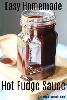 homemade hot fudge sauce in a glass jar with spoon on cutting board and text overlay that reads easy homemade hot fudge sauce