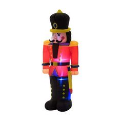 an inflatable nutcracker is shown with its lights on and has a black hat