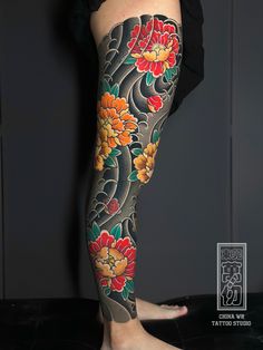 a woman's leg with tattoos on it and flowers in the middle of her legs