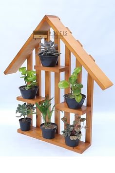 a house shaped plant stand with potted plants