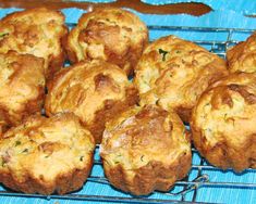 several muffins cooling on a wire rack with blue cloth in the foreground