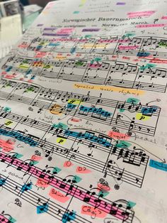 sheet music notes are lined up on top of each other, with colorful writing all over them