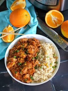 a white bowl filled with rice and oranges next to an instant pot