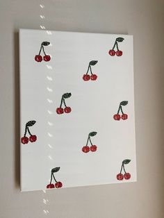 a painting with cherries on it hanging on the wall