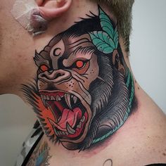 a man with a tattoo on his neck has an angry gorilla head and leaves around his neck