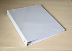 a white binder sitting on top of a wooden table