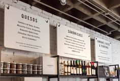 the inside of a restaurant with menus hanging on the wall and shelves full of bottles