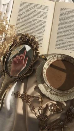 an open book on a table next to a plate with a cross and other items