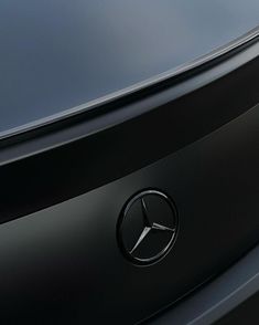 the front end of a black car with a mercedes emblem on it's hood