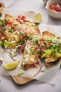 some tacos are sitting on top of napkins next to a bowl of salsa