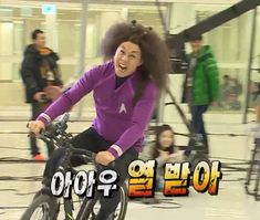 a woman riding a bike with an afro on it