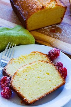 two slices of pound cake on a plate with raspberries