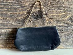 "This is a lovely vintage classic black evening bag. It has a black satin fabric exterior and a black fabric lining on the interior. The handle, leaf-engraved top, and clasp are made of gold tone metals. The handle can be tucked inside of the purse to use as a clutch. Made by Ande. Great purse for a night on the town or special event! It measures 10\" long, 1 1/2\" wide, and 6\" tall. The handle is 10\" long. It is in great vintage condition. Both exterior and interior are in great condition. Pl Formal Satin Evening Bag With Satin Lining, Satin Evening Bag With Satin Lining, Evening Bags With Satin Lining, Vintage Black Evening Bag For Party, Elegant Vintage Black Bag For Formal Occasions, Elegant Vintage Black Formal Bag, Elegant Satin Finish Evening Bag For Formal Events, Elegant Satin Finish Evening Bag For Formal Occasions, Elegant Satin Finish Evening Bag