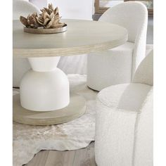 a round table with white chairs around it