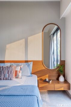 a bedroom with a bed, dresser and mirror in it's corner area next to a window