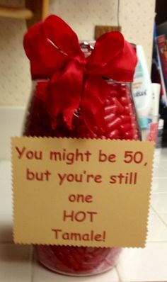 a jar filled with candy and a sign saying you might be 50, but you're still one hot tamale