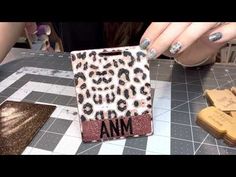 someone is making an animal print phone case with glitter and glue on the top, which reads am