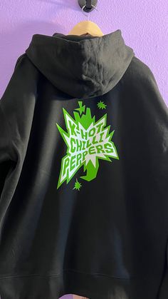 I am making an Ateez Bouncy / K Hot Chilli Peppers inspired zip up hoodies from their new comeback!  They are a blend of cotton and polyester unisex black zip up hoodies made with HTV. On the front there is their new logo and the Bouncy K Hot Chilli Peppers logo on the back in green.  They are a classic fit and lightweight. All orders are made to order so I unfortunately cannot accept exchanges or returns unless the shirt is damaged. Please refer to size chart below and measure accordingly for t Pop Culture Cotton Hoodie With Drawstring Hood, Band Merch Cotton Hoodie With Graphic Design, Cotton Band Merch Hoodie With Graphic Design, Cotton Hoodie With Graphic Design Band Merch, Black Pop Culture Hoodie Sweatshirt, Black Cotton Hoodie With Graphic Design, Pop Culture Black Hoodie Sweatshirt, Black Cotton Hoodie For Fan Merchandise, Black Screen Print Hoodie For Fan Merchandise