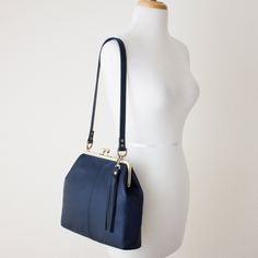 "This lovely handcrafted retro style kiss lock frame handbag is created with your choice of SEVEN semi-structured (not rigid) leather colors (navy, black, dark brown, red, burgundy, blush pink or taupe) and your choice of antique brass finish or silver finish hardware. Also included is a matching hand cut leather tassel handbag charm. You also have the option of an adjustable crossbody strap or the standard shoulder strap. This kiss lock frame handbag has a FULLY LINED black or ivory hopsack lin Leather Tassel Keychain, Bag With Tassel, Leather Frame, Tassel Purse, Frame Purse, Leather Frames, Art Storage, Frame Bag, Beautiful Handbags